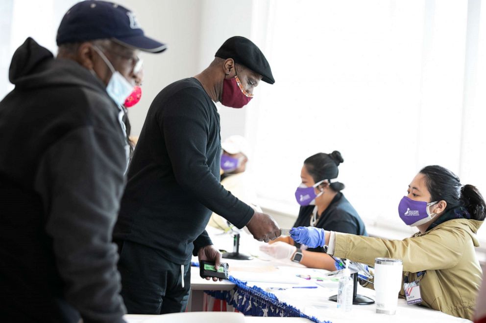 PHOTO: Voters check-in with poll workers to cast their ballots at the Metropolitan Library on Nov. 3, 2020, in Atlanta.