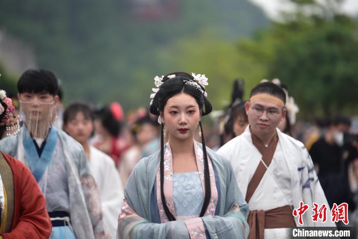 一位女子穿着中国风服饰在巡游队伍中。　王以照 摄