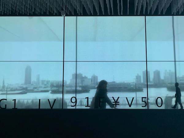 在APSMUSEUM，杨浦滨江的实时传送影像，与馆内行走的人、与邱岸雄的影像叠加。