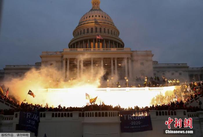 当地时间1月6日，美国参众两院确认选举人团投票结果的联席会议，特朗普支持者闯入国会大厦引发大规模骚乱而被迫中断，现场极度混乱。图为美国华盛顿的美国国会大厦前火光四起。