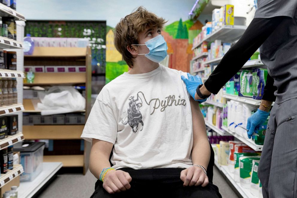 PHOTO: Max Dobles, 17, looks at Dr. Mayank Amin before receiving the Pfizer-BioNTech vaccine against the coronavirus disease (COVID-19) at Skippack Pharmacy in Schwenksville, Pennsylvania, March 3, 2021.