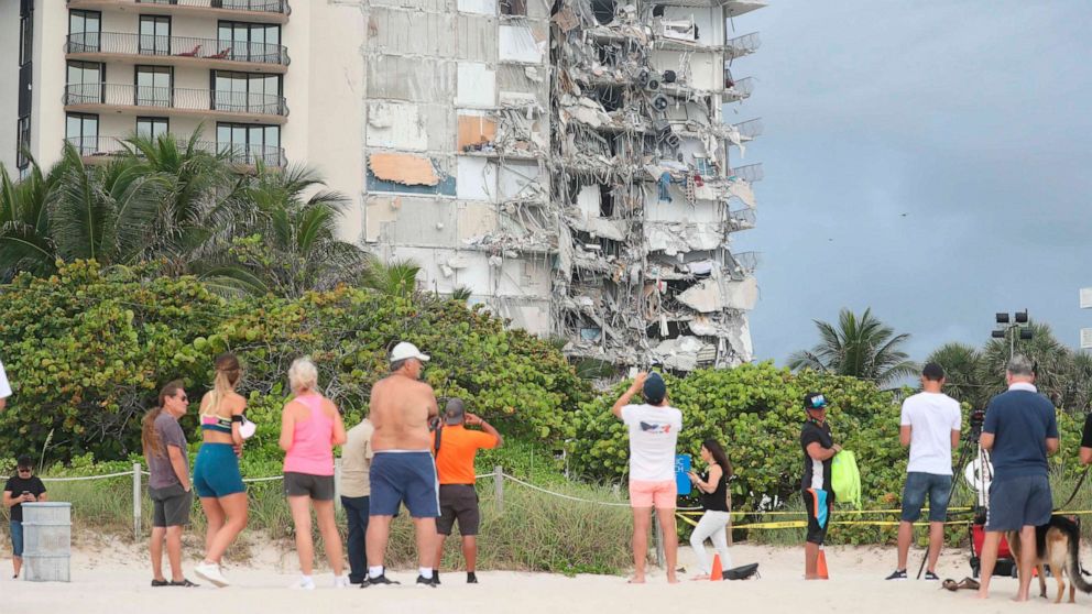 PHOTO: People look at the damage at the 12-story oceanfront Champlain Towers South Condo that collapsed early Thursday, June 24, 2021, in Surfside, Fla.