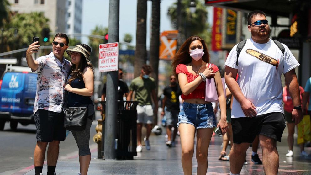 PHOTO: People walk and take photos on Hollywood Boulevard, June 15, 2021, in Los Angeles.
