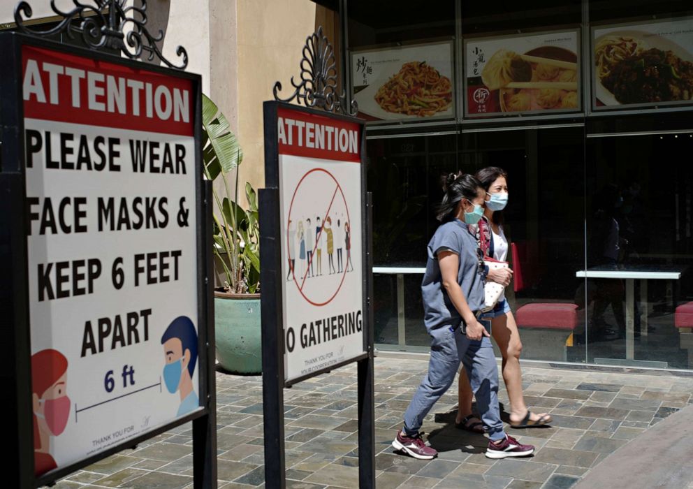 PHOTO: Customers wear face masks in an outdoor mall with closed business amid the COVID-19 pandemic in Los Angeles, June 11, 2021.