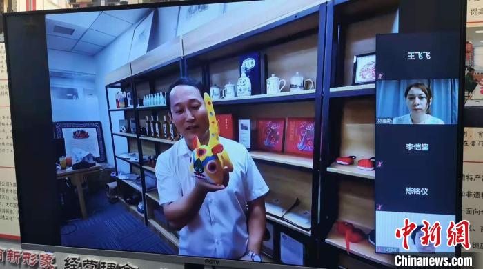 晋门醉非遗文化产业总部基地负责人王俊宝正在向海外华裔青少年介绍非遗产品。　杨杰英 摄