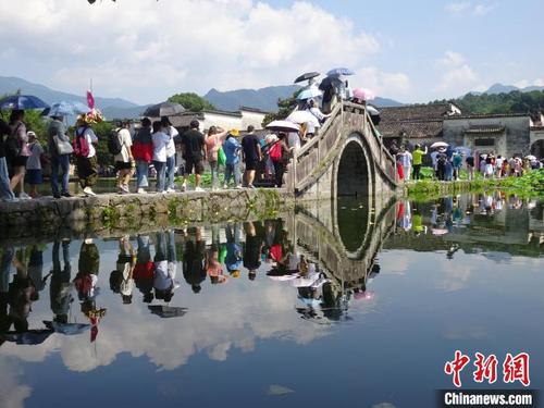 中国侨网宏村景区水清天蓝、绿荷盈湖，八方游客纷至沓来。　吴寿宜　摄