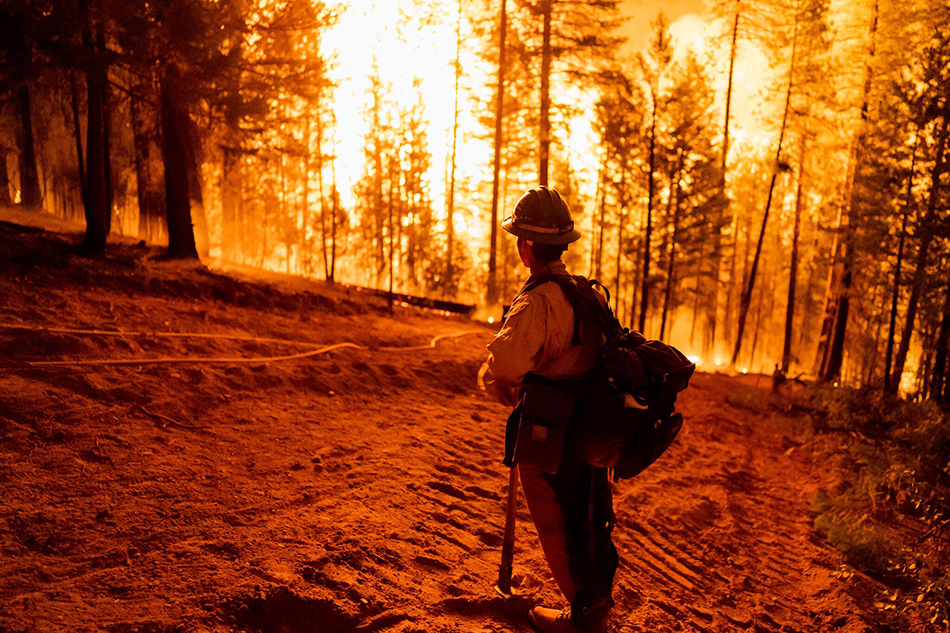 一名消防员在加利福尼亚州昆西附近的迪克西火灾控制区内监测火灾