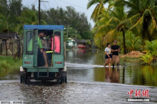 资料图：当地时间8月28日，飓风“艾达”登陆古巴，带来强风降雨天气，古巴阿尔特米萨省Guanimar部分道路被淹。图为汽车在被雨水淹没的街道上行驶。