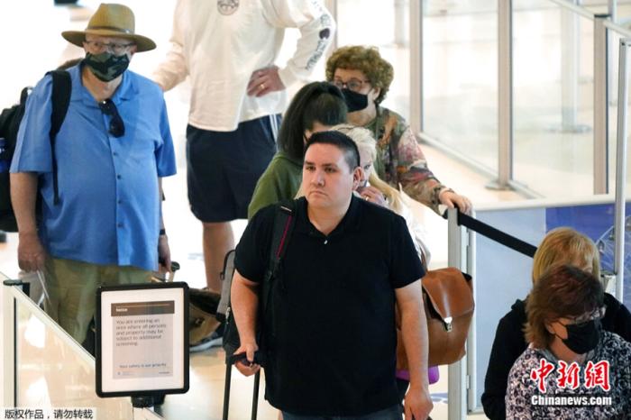 当地时间4月19日，旅客在美国得克萨斯州达拉斯爱田机场排队等候。