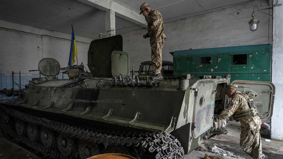 PHOTO: Ukrainian servicemen inspect a Russian MT-LB in the Kharkiv area, eastern Ukraine, May 29, 2022. 