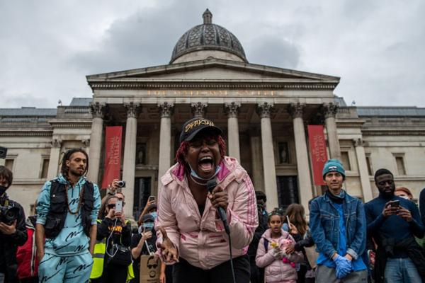 2020年6月12日，伦敦特拉法加广场英国国家美术馆前，反种族游行中，一名女子在歌唱。