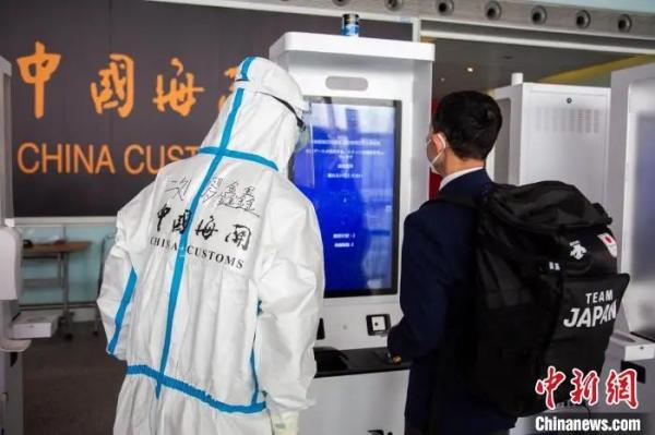 资料图：北京海关所属首都机场海关关员指导冬奥入境旅客使用健康申报验核一体机