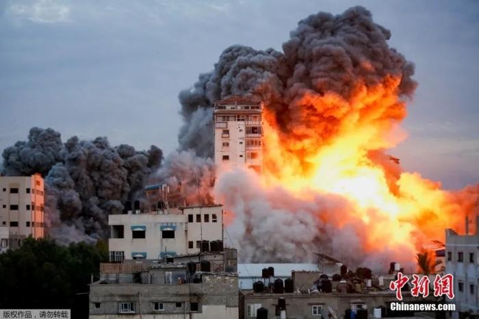 当地时间10月7日，在以色列军队袭击加沙城内一座高楼后，现场火光冲天浓烟滚滚。